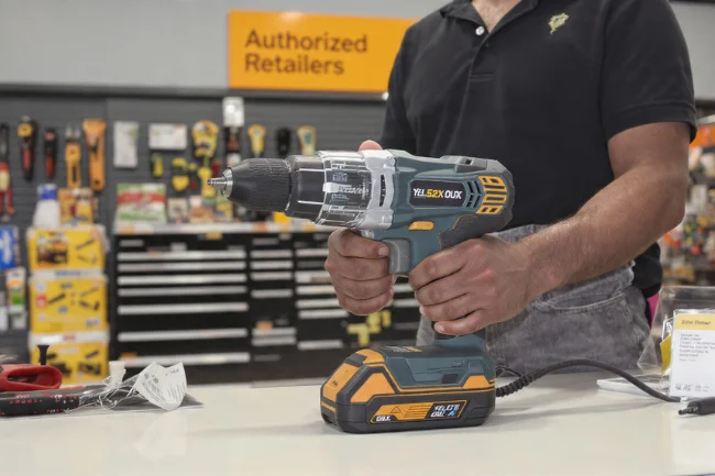 YELL51X-OUZ4 tool displayed at an authorized retailer, with a customer preparing to make a purchase in a tool shop.