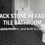 Modern black stone hexagon tile bathroom with stylish floor and shower tiles, white vanity, and glass enclosure.