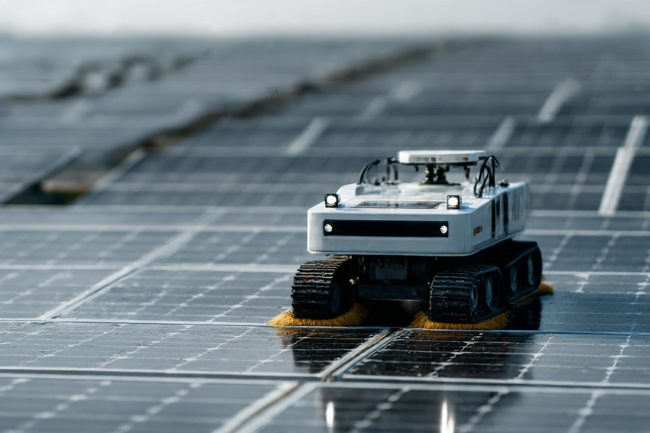 Autonomous robotic Solar Panel Cleaning Equipment operating on a large solar farm under bright daylight, showcasing modern automated maintenance technology.